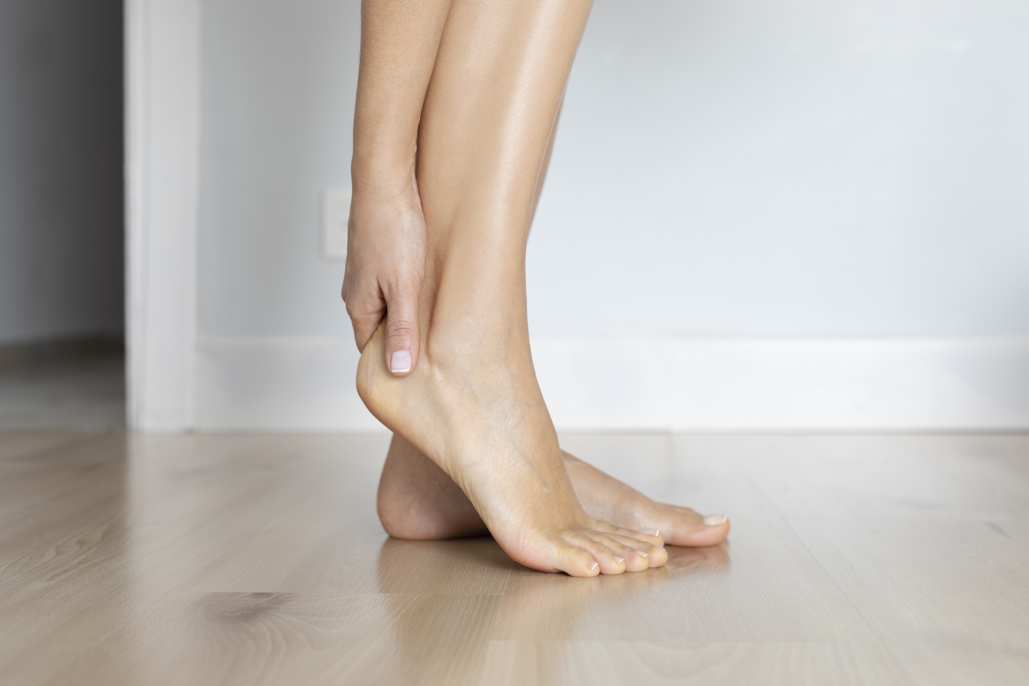 Female is holding her ankle out of pain at home | Sports Injuries