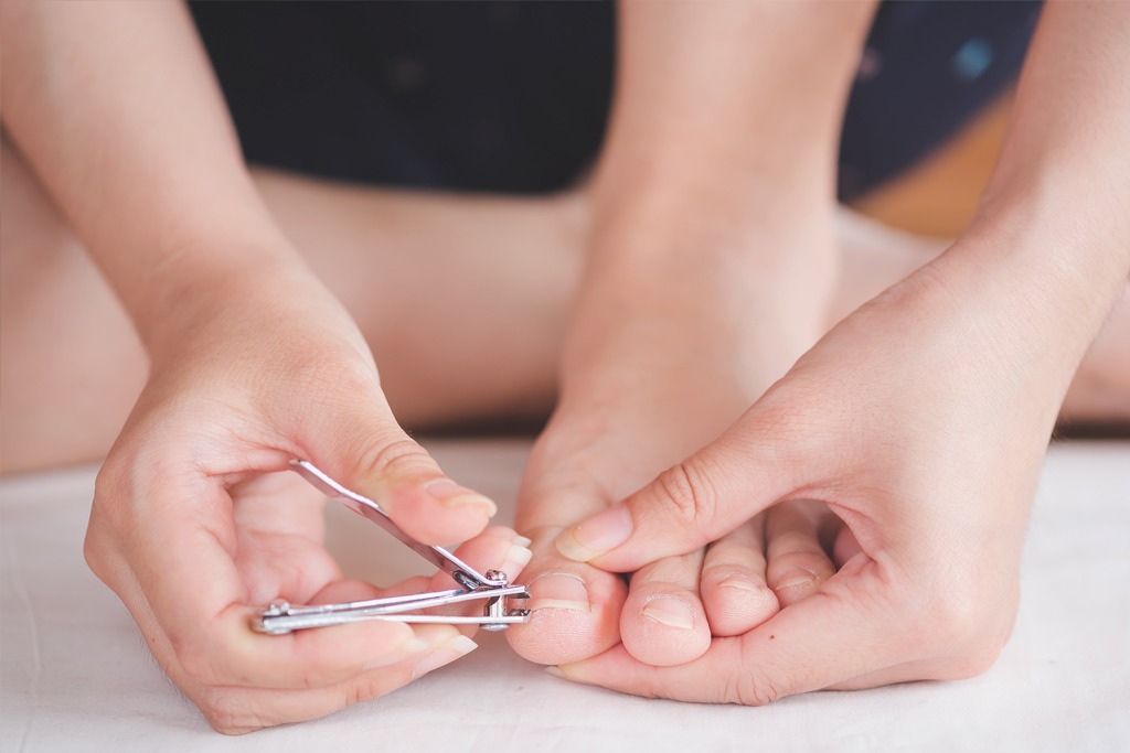 Closeup of a woman cut toenail herself, Foot care treatment and nail, health care concept.